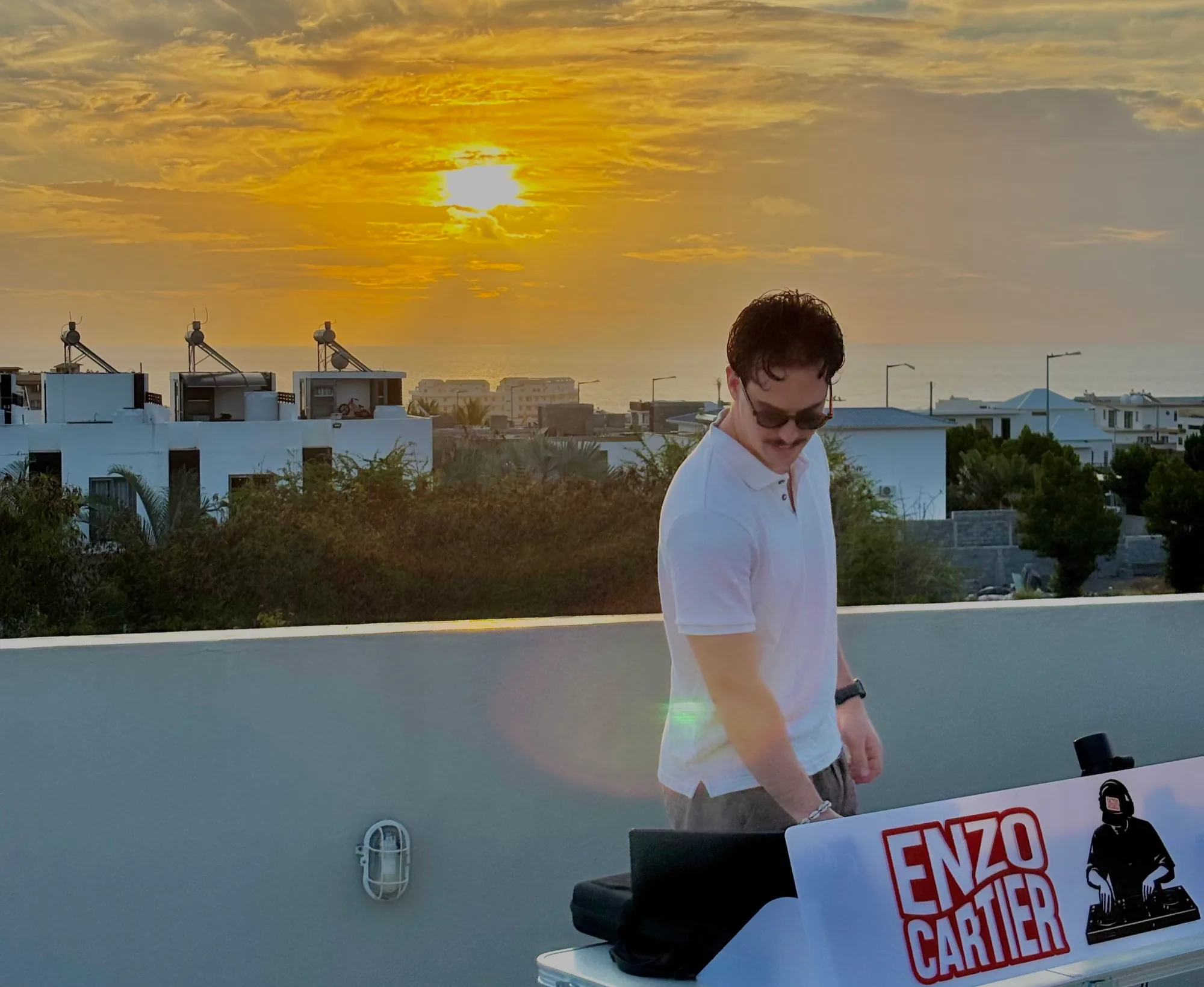 Enzo Cartier aux platines sur un rooftop au coucher du soleil